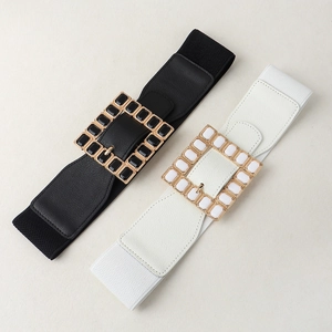 Detail view of black and white elastic waist belts with acrylic rhinestone square buckles