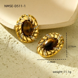 Macro view of oval tiger eye earrings with sparkling cubic zirconia on gold titanium steel