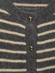 Detailed macro view of grey and white striped knit cardigan with shiny gold buttons
