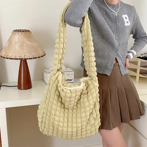 Detail of light yellow bubble textured large capacity crossbody bag with zip closure