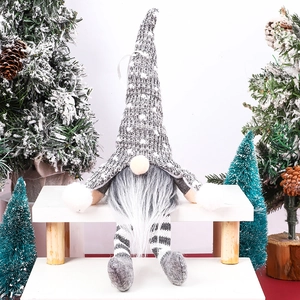 Detail of Christmas forest gnome with grey knitted hat and striped legs on wooden stool