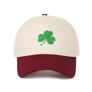 Detailed close-up of green shamrock embroidery on a two-tone cotton baseball cap