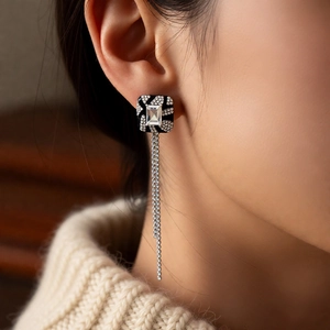 Close-up of vintage square fringe earrings with black enamel and sparkling diamonds