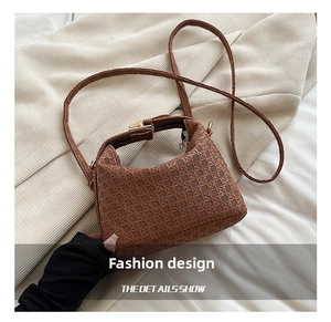 Close-up of deep brown woven texture crossbody bag with vintage gold hardware