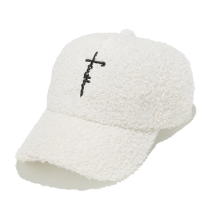 Primo piano del berretto da baseball in sherpa bianco con ricamo croce Faith nero
