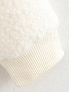 Close-up of the ivory faux shearling fabric and ribbed knit cuffs on this women's jacket