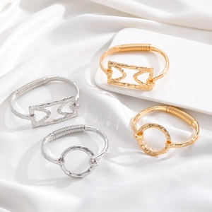 Polished alloy cross and heart bracelets in gold and silver finish on white fabric