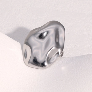 Vue macro d'une bague en acier inoxydable argenté poli avec une forme organique irrégulière