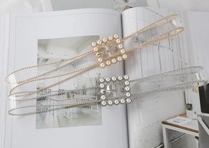 Detail of transparent PVC belts with pearl square buckles and decorative bead edging