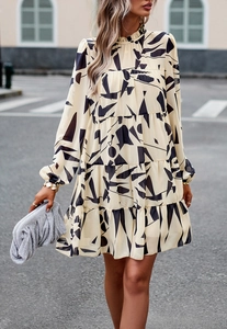 Détail d'une robe beige à volants avec imprimé abstrait noir et manches longues style urbain