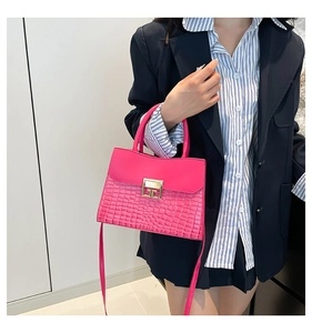 Vista dettagliata della borsa rosa con goffratura coccodrillo e fibbia dorata su modella