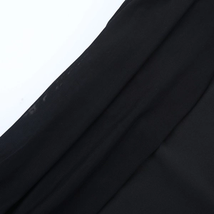 Close-up of black mesh fabric stitching on an off-shoulder dress with fine texture