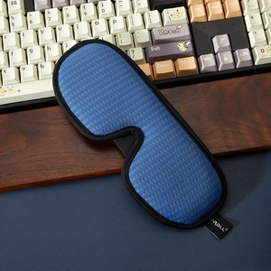Close-up of breathable 3D sleep mask with blue honeycomb mesh and soft black piping