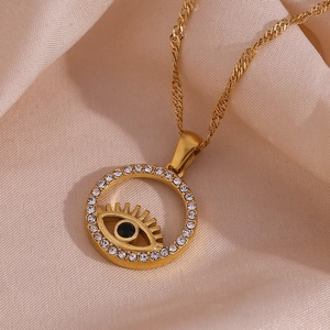 Detail of 18K gold-plated Evil Eye necklace with crystals on luxury champagne satin