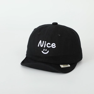 Detail of nice smiley face embroidery on a black soft brim kids baseball cap