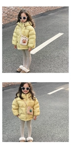Close-up of a yellow hooded winter jacket for girls featuring a minimalist smile embroidery