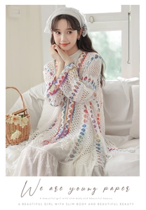 Dettaglio del cardigan all'uncinetto bianco con strisce colorate e foulard in pizzo