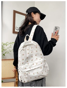 Side view of white floral backpack with pink flowers and functional front zipper pocket