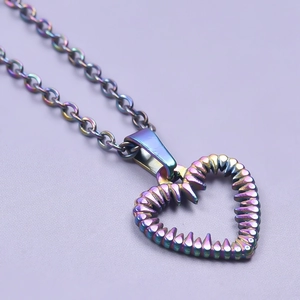 Macro shot of a rainbow stainless steel hollow heart necklace with textured finish detail