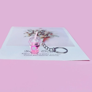 Macro shot of pink fruit tea cup keychain with glitter liquid and dragon fruit motif