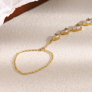 Détail d'un bracelet de doigt plaqué or 18K orné de cinq zircons taillés en poire
