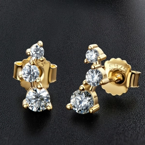 Macro view of gold S925 sterling silver stud earring with three graduated moissanite stones