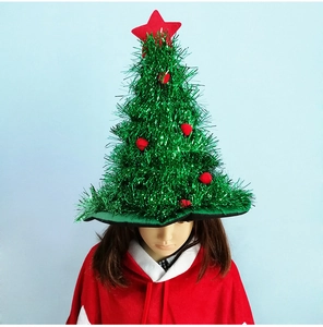 Detail of Christmas tree hat with green tinsel, red pompoms and star decoration