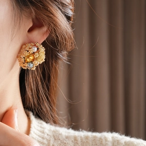 Gros plan de boucles d'oreilles fleur vintage avec pierre ambre et perle grise