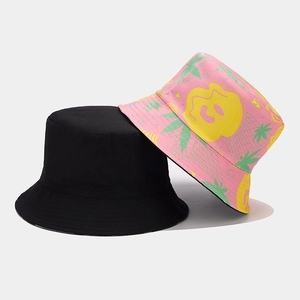 Detail view of double-sided bucket hats in solid black and colorful floral print designs