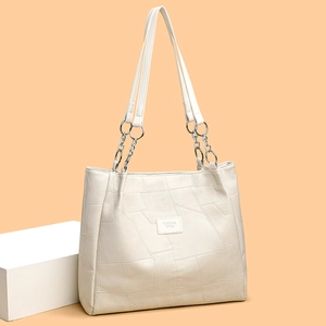 Cream white puzzle texture tote bag with silver chain straps and elegant minimalist design