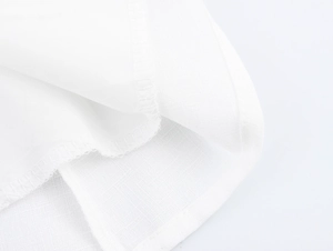 Dettaglio macro del tessuto in cotone bianco con orlo pulito e trama intrecciata