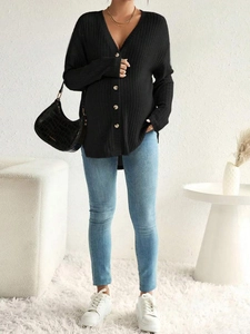 Close-up of black V-neck buttoned knit maternity cardigan with casual jeans and handbag