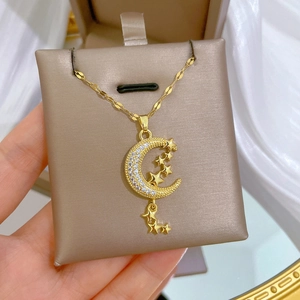 Luxurious gold star and crescent moon necklace with zircons on a jewelry box