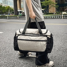 City street shot of a beige and black dual-tone yoga travel bag with wrinkled texture