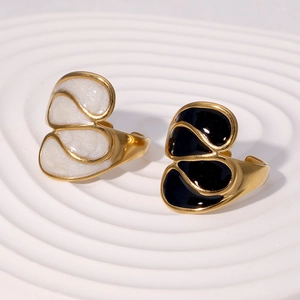 Detailed close-up of 18k gold-plated irregular rings with black and white enamel inlays