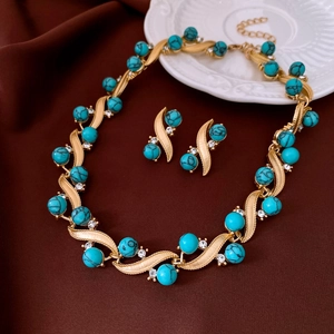 Vintage gold jewelry set with turquoise beads and sparkling rhinestones on brown silk