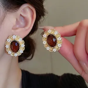 Vintage gold earrings with amber oval stones and white enamel floral borders