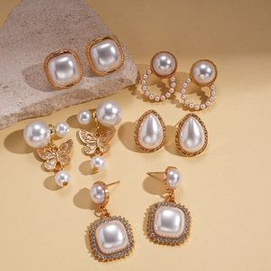 Set of five gold pearl earrings featuring waterdrop and butterfly geometric shapes