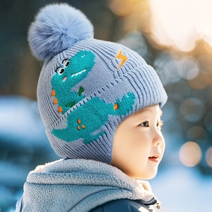 Cappello in maglia celeste per bambini con motivo a dinosauro e morbido pompon in pelliccia