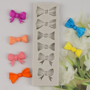 Detail of grey silicone mold with six different bow shapes for chocolate fondant decorating