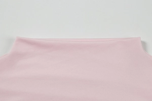 Close-up of pink off-the-shoulder neckline detail showing fine stitching and knit texture