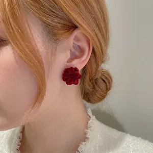 Elegant red flocked flower stud earrings with French vintage style on a model