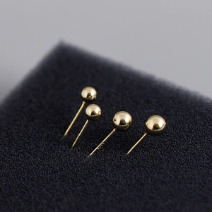 Close-up of minimalist 5mm gold plated S925 sterling silver ball stud earrings on black base