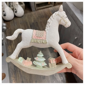 Detail of resin rocking horse ornament with pink saddle and tiny Christmas tree