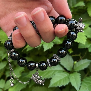 Gothic beaded bracelet with black beads featuring a dragon head charm and bell pendant