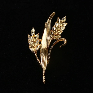 Elegant gold wheat brooch with sparkling crystals on a luxurious black velvet background
