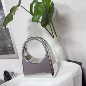 Detail of silver mirror acrylic handbag showing the unique curved geometric design