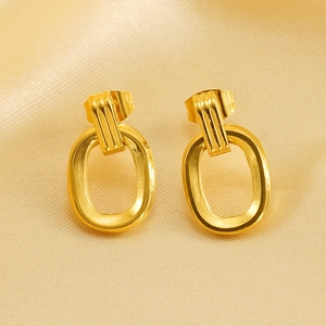 Retro double hoop gold stainless steel earrings on elegant champagne satin fabric