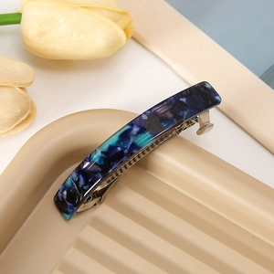 Vista dettagliata di un fermaglio per capelli in acetato blu navy su vassoio ondulato