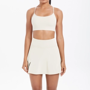 Detailansicht des cremefarbenen Yoga-Sets mit Sport-BH und hochtailliertem Tennisrock